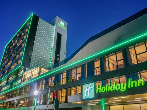 un edificio con un letrero de posada delante de él en Holiday Inn Antalya - Lara, an IHG Hotel, en Antalya