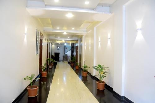 a hallway with potted plants in a building at Hotel Parag in Pune