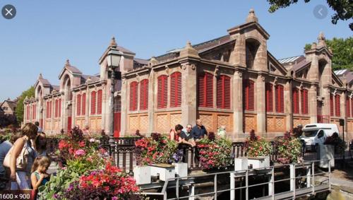 um grande edifício com flores em frente em belle lauch em Colmar