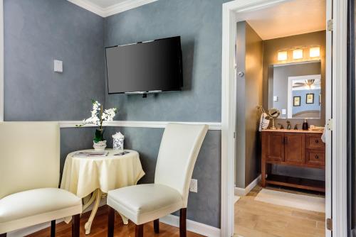 a dining room with a table and chairs and a television at Bouchard Restaurant & Inn in Newport