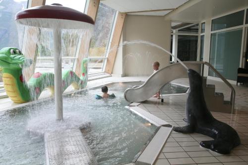 een kind in een zwembad met een fontein bij Hotel Union Geiranger Bad & Spa in Geiranger