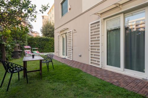 een patio met 2 stoelen en een tafel in het gras bij Villa Capri Apartment and Room in Napels