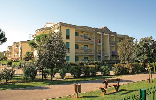 un parque con un banco frente a un edificio en TIGLI Lido Altanea, en Caorle