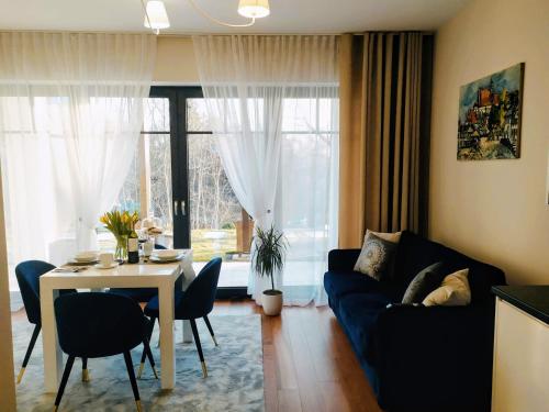 a living room with a blue couch and a table at Apartamenty RÓŻANA 2 in Nałęczów