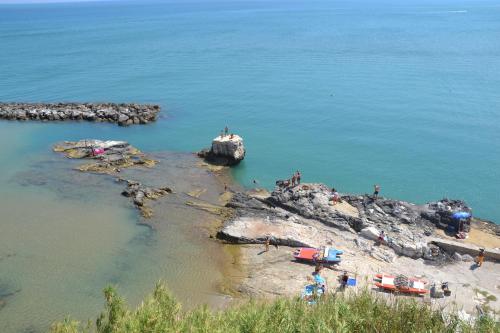 Un gruppo di persone che si trovano su una roccia nell'acqua di Cuore di Vieste a Vieste