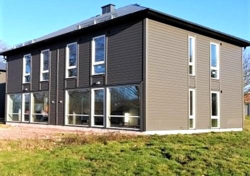 a large house with windows on the side of it at Saxnäs Ferieboende L. Erik in Färjestaden