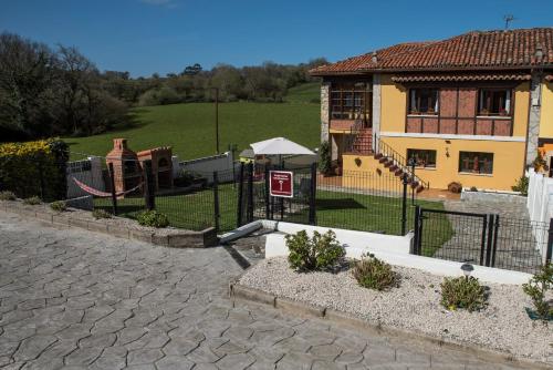 a fence in front of a house with a playground at Apartamentos Alegría in Santillana del Mar