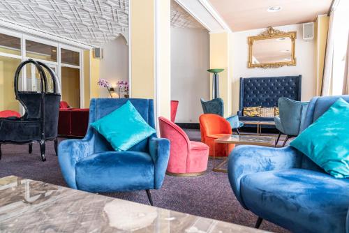 a living room with blue chairs and a table at Hotel Europe in Davos