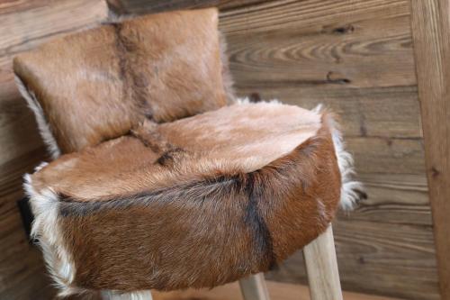 une chaise brune assise au-dessus d'une table en bois dans l'établissement Petit Chalet Blanc Cervinia, à Breuil-Cervinia