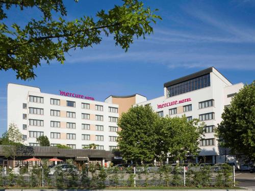 Biały budynek z czerwonymi literami w obiekcie Mercure Hotel am Messeplatz Offenburg w mieście Offenburg