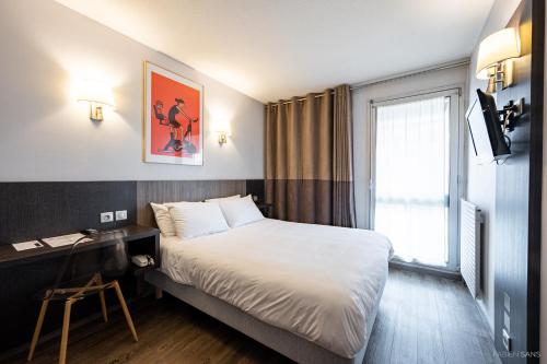 a hotel room with a bed and a desk and a window at Hotel Gascogne in Toulouse