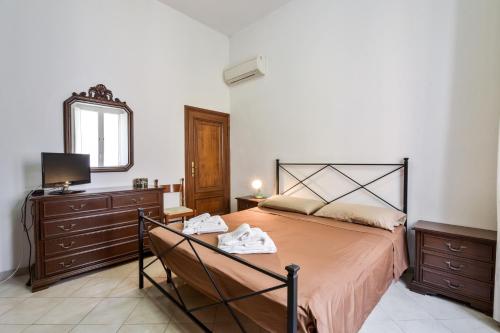 1 dormitorio con cama, tocador y espejo en Apartment with balcony in Porto Santo Stefano 89 m² sea view, en Porto Santo Stefano