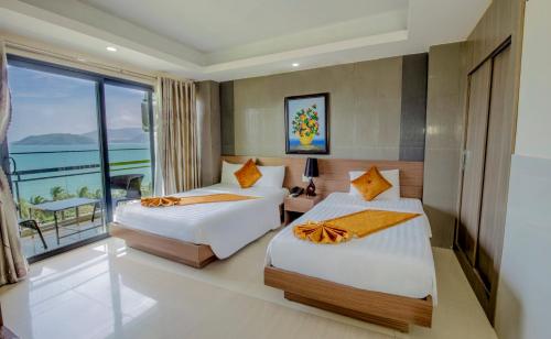 Habitación de hotel con 2 camas y balcón en Oliver Hotel, en Nha Trang