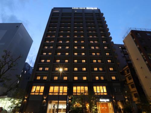 um edifício preto alto com muitas janelas em Dormy Inn Ikebukuro em Tóquio