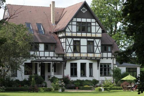 Casa blanca con techo marrón en Gutshaus Kubbelkow, en Bergen auf Rügen