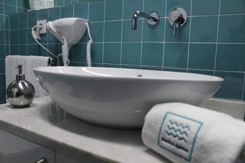 La salle de bains est pourvue d'un lavabo blanc et de carrelage bleu. dans l'établissement Beachfront Apartment Nazaré, à Nazaré