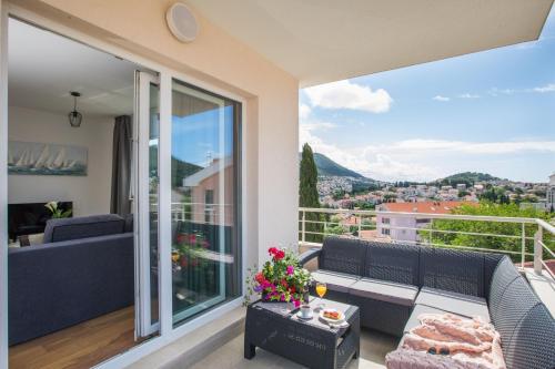 balcón con sofá y vistas a la ciudad en Apartment Navis, en Dubrovnik