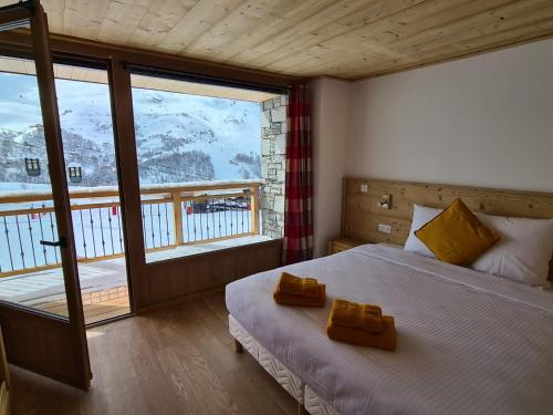 1 dormitorio con cama y ventana grande en Chalet Le Granitic, en Les Menuires