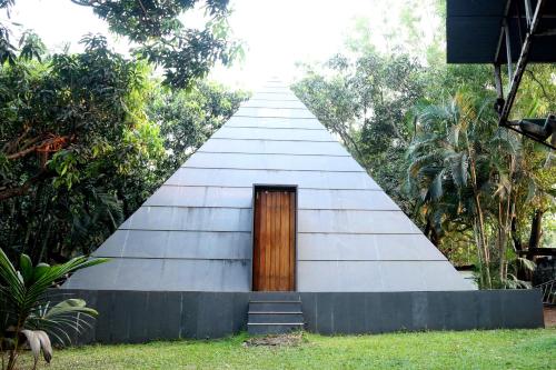 un edificio alto con una porta di legno di Outpost@Alibaug ad Alibaug