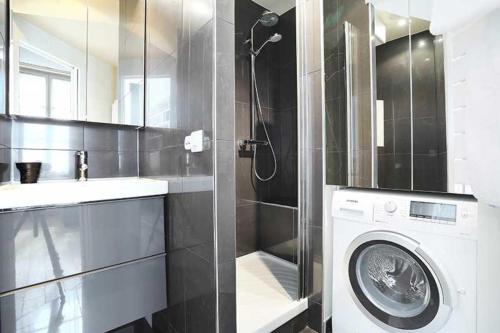 bagno con lavatrice e lavandino di Residence central marais a Parigi