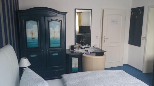 een slaapkamer met een zwarte kast en een wastafel bij Landhotel Ostseetraum & Fewo in Warnemünde