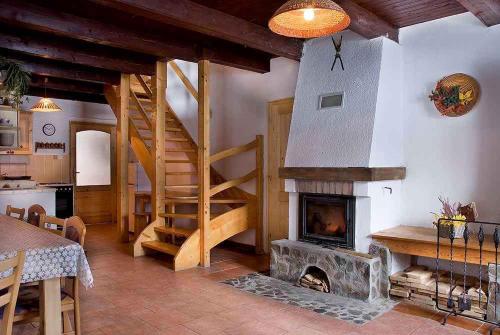 een woonkamer met een open haard en een trap bij Holiday home in Cerna v Posumavi 1908 in Černá v Pošumaví