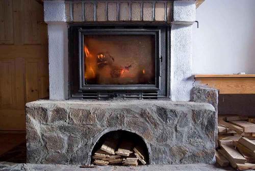 een stenen open haard met een tv erop bij Holiday home in Cerna v Posumavi 1908 in Černá v Pošumaví