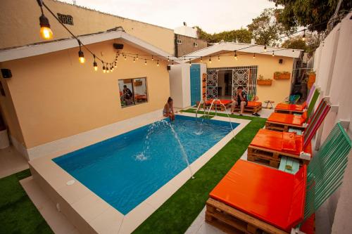 a swimming pool in a house with a child playing in it at Hostal El Bando in Cartagena de Indias