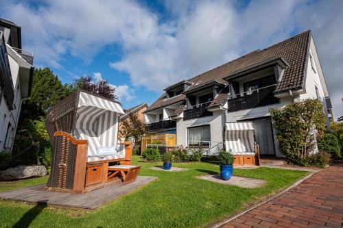 een huis met een bank in de tuin bij Das Frühstückshotel Büsum in Büsum