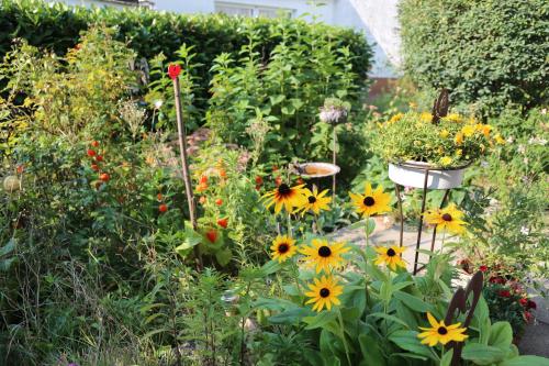 un giardino pieno di fiori gialli e arancioni di FeWo "Regnitztraum" in Forchheim - 3-Zimmer-Apartment - 2 Schlafzimmer a Forchheim