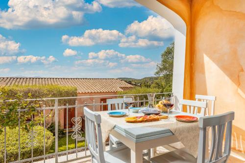 una mesa y sillas en un balcón con vistas en Shanti House Olbia, en Olbia