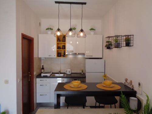 uma cozinha com uma mesa com dois pratos em Apartman M Orebic em Orebić