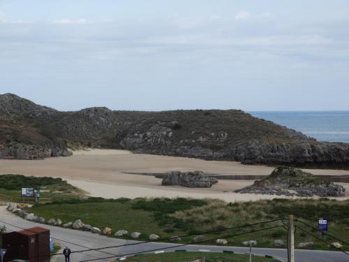 uma vista para uma praia com rochas e o oceano em Hotel Los Juncos em Noja