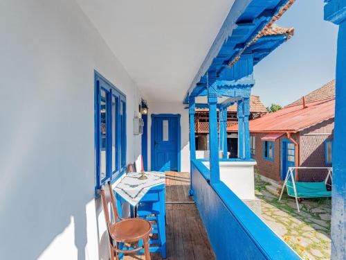 a blue balcony with a table and a chair at Casa de vacanta traditionala romaneasca in Schiuleşti