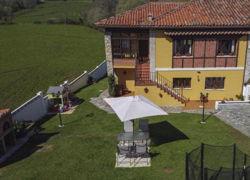 a house with a white umbrella in the yard at Apartamentos Alegría in Santillana del Mar