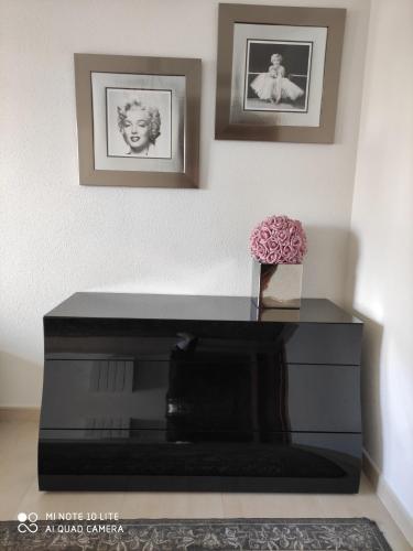 een zwarte piano in een kamer met twee foto's aan de muur bij Apartamento Salou lux por precio económico. in Salou