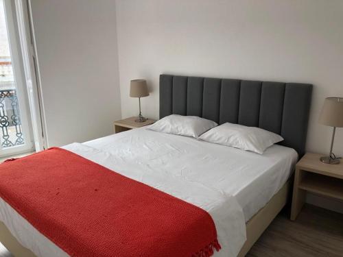 Be Lisbon Hostel Intendente في لشبونة: غرفة نوم بسرير كبير مع بطانية حمراء