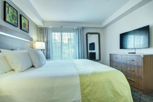 1 dormitorio con 1 cama grande y TV en Desert Rose Resort, en Las Vegas