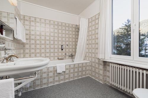 bagno con lavandino e finestra di Kurhaus Lenzerheide a Lenzerheide