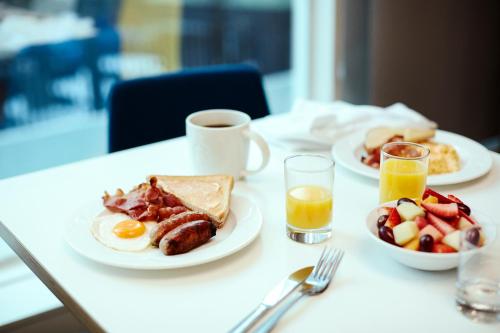 - une table avec deux assiettes de produits pour le petit-déjeuner et une tasse de café dans l'établissement Holiday Inn & Suites - Toledo Southwest - Perrysburg, an IHG Hotel, à Perrysburg