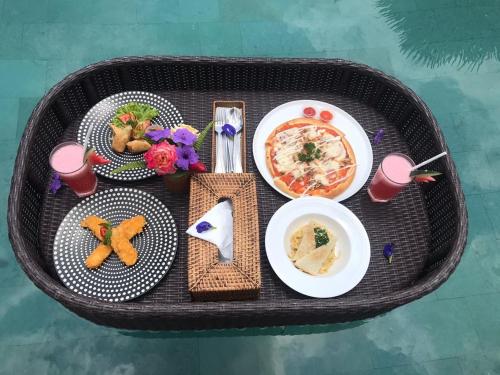 una mesa con platos de comida y bebidas. en Pondok Sebatu Eco Lodge, en Tegalalang