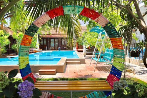 uma piscina com um arco colorido num quintal em MAY Bungalow em Mui Ne