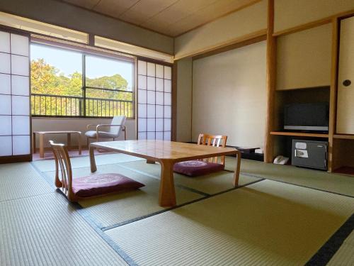 een kamer met een tafel en stoelen en een raam bij Miyajima Morinoyado in Miyajima