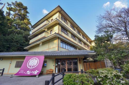 een gebouw met een roze bord ervoor bij Miyajima Morinoyado in Miyajima