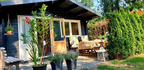 un porche de una casa con un banco y algunas plantas en GUESTHOUSE in een mooie tuin in het centrum van Zuidlaren!, en Zuidlaren