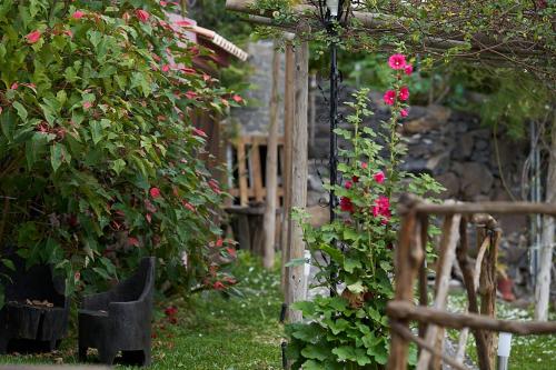 un giardino con fiori rosa e una recinzione in legno di Ga281 a Funchal