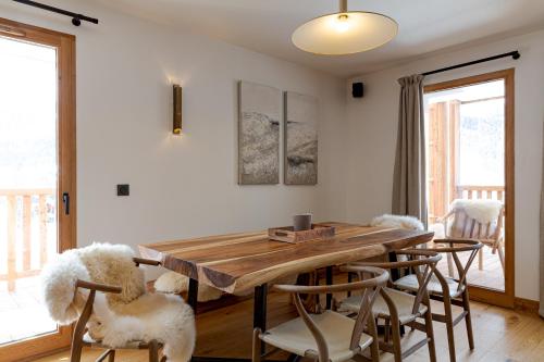 uma sala de jantar com uma mesa de madeira e cadeiras em Le Refuge des Anges em Megève