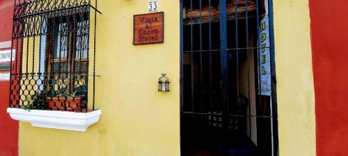 a yellow building with a window and a sign on it at Hotel Vista al Cerro in Antigua Guatemala