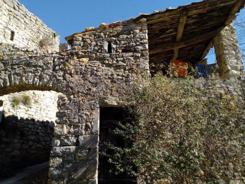 un antiguo edificio de piedra con techo de madera en Gite des Gorges de l'Ardèche, en Chame