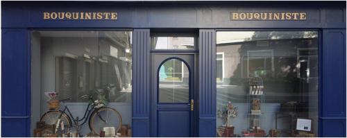 Una tienda azul con una bicicleta estacionada frente a ella. en Le Bouquiniste, atypique, cosy, fibre, BedinShop, en Romans-sur-Isère